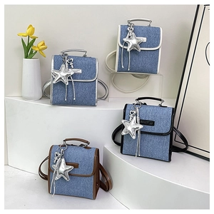 Mini denim handbags in four colors with star charms displayed on white podiums