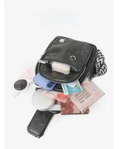 Spacious black pebbled chest bag with chevron strap and organized compartments for essentials