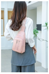 Pink crossbody bag detail with textured PU leather and woven geometric shoulder strap