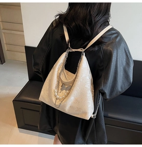 Détail du sac à dos blanc avec gaufrage papillon et chaîne décorative en perles