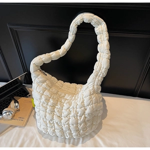 Detail of white quilted puffer cloud bag with textured fabric and soft padded structure