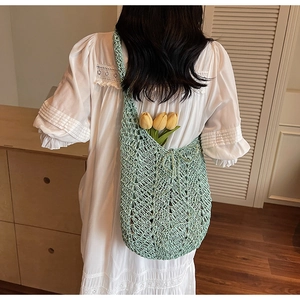 Detail of mint green crochet tote bag featuring hollow diamond pattern and drawstring bow