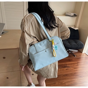 Grande borsa tote in tela azzurra con ciondolo a stella portata a spalla per l'uso quotidiano