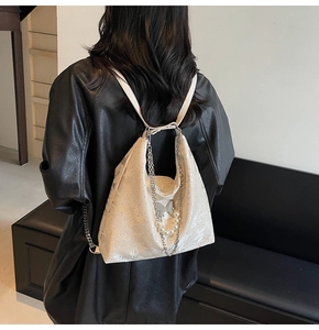 Détail du sac en denim avec pendentif papillon et décoration de chaîne de perles
