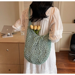 Detail of mint green crochet tote bag featuring a honeycomb openwork pattern and strap