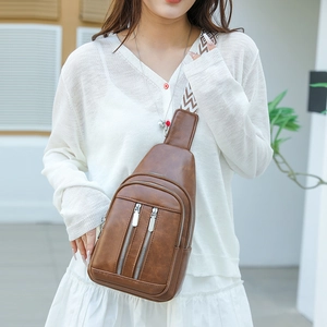 Brown PU leather chest bag with ethnic woven strap worn by a model in soft light
