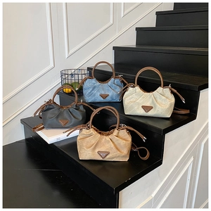 Detailed view of four pleated nylon crossbody bags in blue, beige, grey, and brown