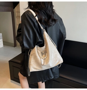 Détail du sac à main blanc crème avec motifs papillon gaufrés et chaîne de perles
