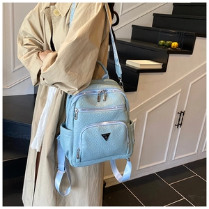 Detail of light blue lychee texture backpack with metallic logo and jacquard strap