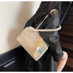 Dettaglio di una borsa tote in tela crema con spalline sottili e ciondolo a stella