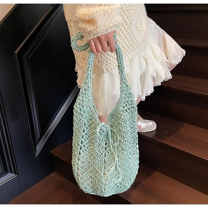 Detail of mint green crochet knit tote bag showing intricate hollow weave patterns