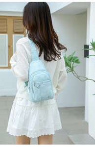 Close-up of light blue PU leather chest bag with a geometric pattern strap on model
