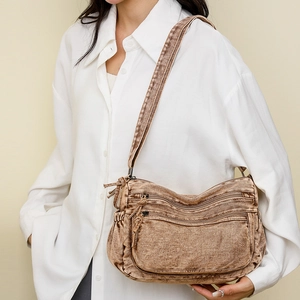 Gros plan du sac fourre-tout en denim marron délavé avec compartiments et style rétro