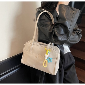 Dettaglio borsa tote in tela beige con ciondolo a stella e tasca esterna con bottone