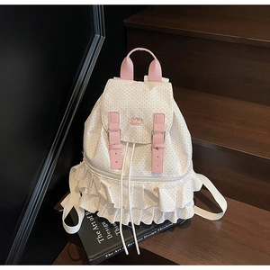 Detail of white polka dot backpack with ruffled trim and pink buckle closure