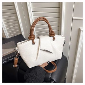 Detailed macro view of white lychee pattern leather tote bag with leaf-shaped silver buckle