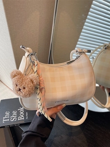 Fashionable checkered underarm bag in cream and orange with a cute plush bear pendant