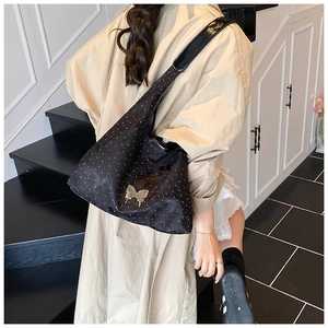 Detail der schwarzen Hobo-Tasche mit glitzernden Strasssteinen und goldener Schmetterlingsschnalle