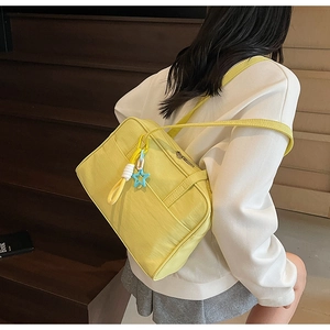 Dettaglio della borsa tote in nylon giallo con ciondolo a stella blu e tracolla