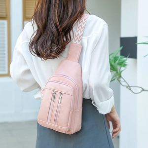 Detail of light pink crossbody chest bag with triple silver zippers and geometric strap
