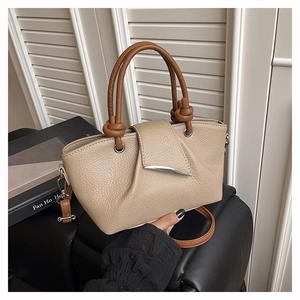 Detailed view of beige lychee texture tote with silver hardware and pleated flap design