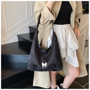 Detailansicht der schwarzen Hobo-Tasche mit Polka-Dots und silberner Schmetterlingsschnalle