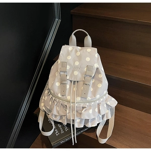 Detailed view of dusty purple polka dot backpack with ruffled trim and drawstring closure