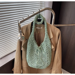 Detail view of mint green hollow crochet knit tote bag with elegant wave pattern texture