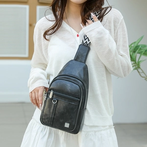 Detail of black PU leather chest bag with wave patterned strap on a fashion model