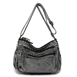 Vue détaillée du sac bandoulière en denim gris foncé avec plusieurs compartiments zippés