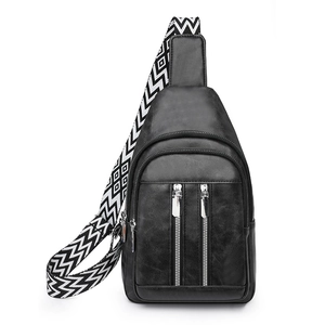 Close-up of black PU leather chest bag with dual zippers and geometric woven strap