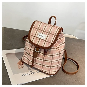 Detail of canvas mini backpack featuring pink plaid pattern and brown leather trim