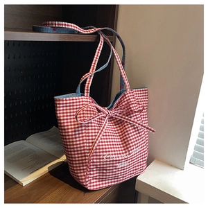 Detail of red checkered canvas tote bag with Rise and Shine embroidery and blue denim bow