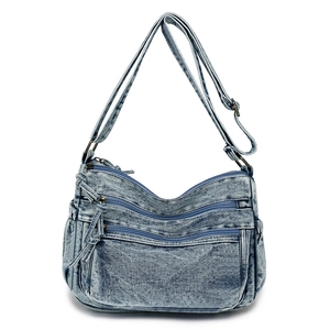 Détail du sac en jean délavé vintage avec plusieurs poches zippées fonctionnelles