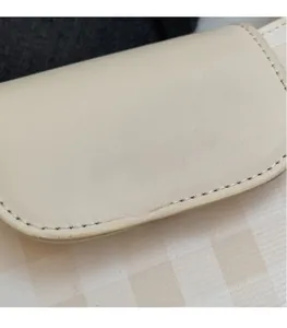 Detail of beige leather texture with silver embossed fashion text and fine stitching