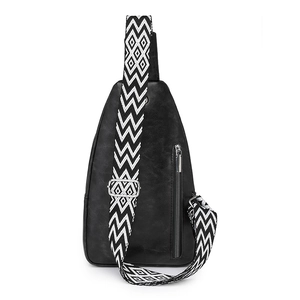 Detail view of the black crossbody bag showing its adjustable geometric patterned wide strap