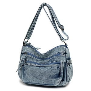 Détails d'un sac à bandoulière en denim délavé avec poches multiples et boucles en bronze