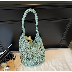 Detail showing the lightweight light green crochet hollow mesh knit texture of the tote bag