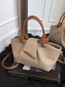 Minimalist beige lychee grain tote bag with brown knotted handles and metal trim decoration