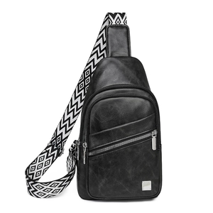 Detail of black pebbled PU leather chest bag with geometric woven strap and metal zipper