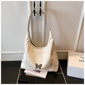 Detail der cremefarbenen Hobo-Tasche mit silbergrauer Jacquard-Blumen und Metallschmetterling