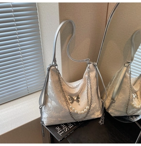 Détail du sac Hobo en dentelle florale blanche avec chaîne de perles et boucle papillon