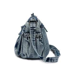 Détail du sac en jean avec poche latérale élastique et boucles en métal bronzé