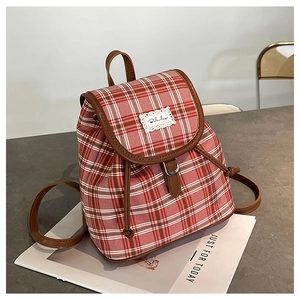 Detail of red and white plaid mini backpack with brown leather trim and drawstring