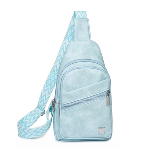 Detail of light blue crossbody bag with textured leather and patterned woven strap