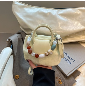 Détail du mini sac en PU crème avec poignée en perles de résine colorées et bandoulière