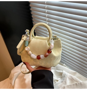 Detail du sac seau jaune clair avec des perles en resine colorees et aspect mat
