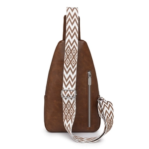 Detail of vintage brown leather chest bag with a wide geometric woven shoulder strap