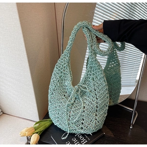 Detail view of mint green hollow crochet tote bag with drawstring and woven texture