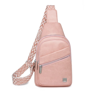 Close-up of pink leather chest bag with ethnic pattern wide strap and metal hardware